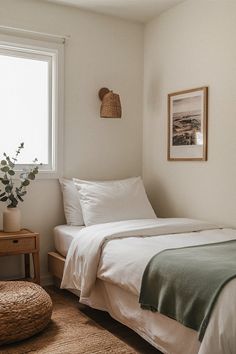 a bed sitting next to a window with white sheets and pillows on top of it