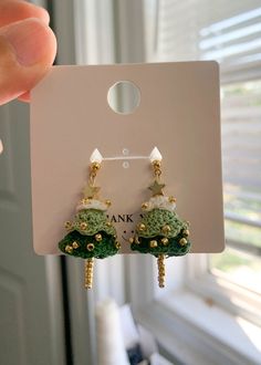 a pair of earrings is shown in front of a white card board with the word bank on it