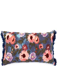 a blue and pink floral pillow with fringes on the bottom, sitting on a white surface