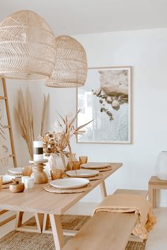 a dining room table with plates, bowls and vases on top of the table