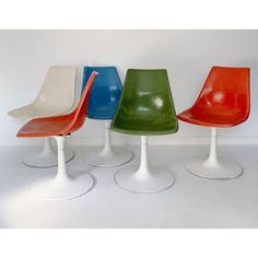 four different colored chairs sitting next to each other