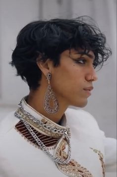 a close up of a person wearing some kind of necklace and earring on their head