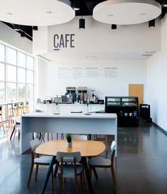 the interior of a coffee shop with tables and chairs