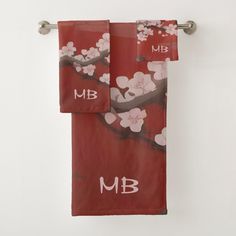 two towels hanging on a towel rack in front of a white wall with cherry blossoms