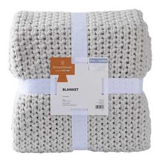 the blanket is knitted in white and has a blue ribbon around it's edge