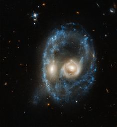 two spiral shaped objects in the middle of a dark sky filled with stars and dust