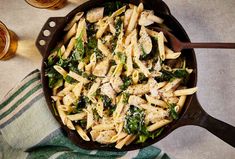 a skillet filled with pasta and spinach