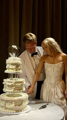 a bride and groom cutting their wedding cake