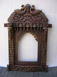 an ornate wooden frame with two birds on it