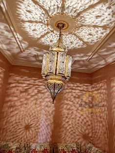 a chandelier hanging from the ceiling in a room with pink walls and curtains