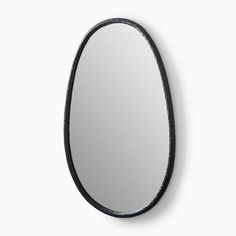 the oval mirror is black and has an oval frame on it, with a curved edge