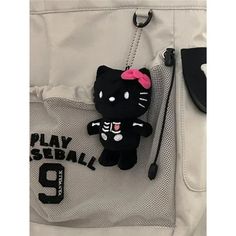 a hello kitty keychain with a pink bow on it sitting in a pocket