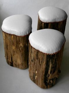 three wooden stools covered in snow sitting next to each other