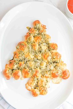 a white plate topped with shrimp and broccoli florets covered in cheese