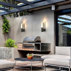 an outdoor living area with couches, table and grill