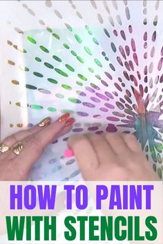 someone is painting with stencils on paper and using them to make an art project