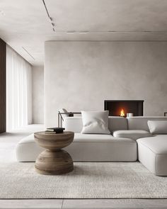 a living room with a large white couch and fire place in the wall behind it