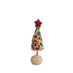 a small toy tree made out of candies on top of a wooden ball holder