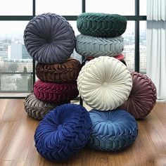 a pile of different colored tires sitting on top of a wooden floor next to a window