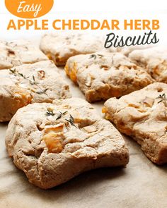 freshly baked biscuits are arranged on a piece of parchment paper with rosemary sprigs