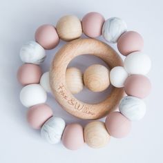 a wooden bead with pastel and white balls around it on a white background