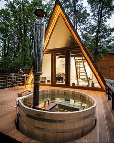 a hot tub sitting on top of a wooden deck next to a building with stairs