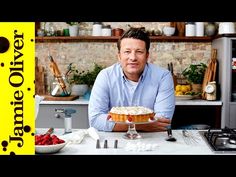 a man sitting at a table with a cake in front of him