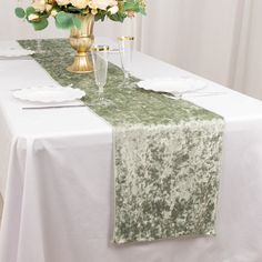 the table is set with white and green flowers