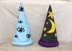 two small witches hats sitting on top of a table next to each other with eyes painted on them