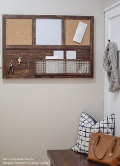 a bulletin board mounted to the side of a wall next to a purse on a bench