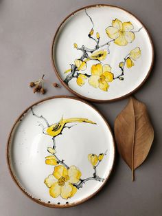 two plates with yellow flowers painted on them