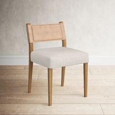 a white chair sitting on top of a hard wood floor next to a gray wall