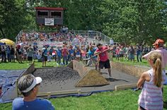 some people are standing in front of a crowd and one is shoveling dirt into the ground