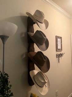 several hats are hanging on the wall next to a lamp