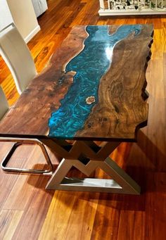 a table that has been made to look like a river in the wood with metal legs