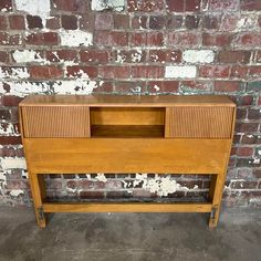 an old wooden dresser against a brick wall