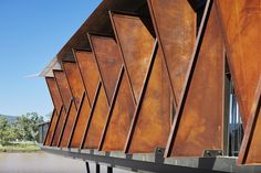 the side of a building that has many triangular shaped metal panels on it's sides