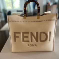 This Is An Authentic Fendi Vitello King Plexiglass Logo Embossed Large Fendi Sunshine Shopper Tote In White Ice. This Stylish Shopping Tote Is Crafted In Cream Leather With Stitched Detailing, And Features Resin Tortoise Shell Top Handles, Gold Hardware And A Bold, Embossed Fendi Logo. The Top Opens To A Spacious Beige Microfiber Interior With A Leather Base. Includes: Dust Bag, Not Included Strap Size Base Length: 15.75 In Height: 13.75 In Width: 7.50 In Drop: 4.50 In Fendi Sunshine, Fendi Peekaboo Bag, Fendi Tote, Fendi Bag, Fendi Peekaboo, Favorite Handbags, Luxury Purses, Cheap Bags, Pretty Bags