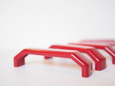 three red plastic objects sitting on top of a white table