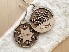 two personalized christmas ornaments on a towel