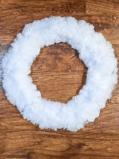 a white fluffy wreath on top of a wooden table