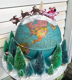 a globe with christmas trees and santa clause on top