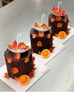 three cakes decorated with fall leaves and umbrellas on top of each other, sitting on a table