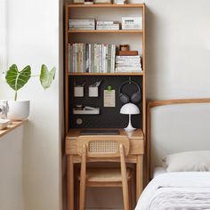 a bedroom with a desk and bookshelf next to a bed in front of a window