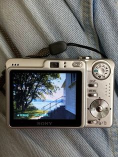 a silver camera sitting on top of someone's lap