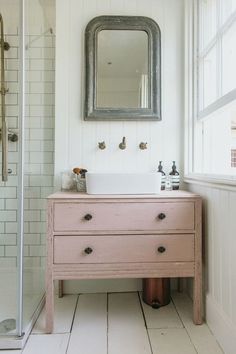 a bathroom with a sink, mirror and shower