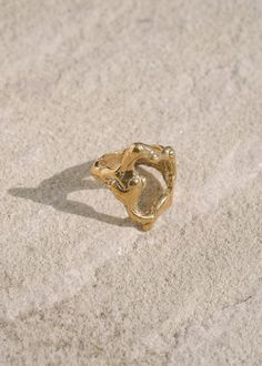 The Tecopa Ring is a bold, abstract piece inspired by the Tecopa Hot Springs in the Mojave Desert. This large ring features an open shape with a distinctive melted texture, capturing the raw and rugged beauty of its namesake. Handcrafted from an original wax carving and cast in recycled brass, the Tecopa Ring embodies modernist and brutalist design principles. Perfect for those who appreciate striking and unconventional jewelry, this piece stands out with its artistic and edgy aesthetic. Its unique design ensures it becomes a conversation starter, whether worn daily or for special occasions. Sizes 5-10. Handmade to order in Los Angeles. Please allow us time to craft the ring for you. Silver Casting Jewelry, Wax Cast Ring, Goldsmith Aesthetic, Lost Wax Ring, Organic Gold Jewelry, Wax Carving Ring, Unconventional Jewelry, Wax Carved Ring, Lost Wax Casting Jewelry