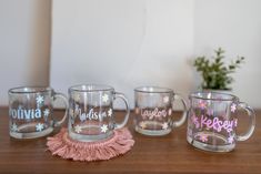 three glass mugs sitting on top of a wooden table