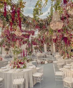 tables and chairs are set up for a wedding reception with chandeliers hanging from the ceiling