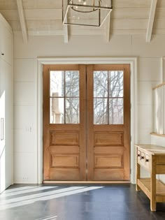 two wooden doors are open in a white room